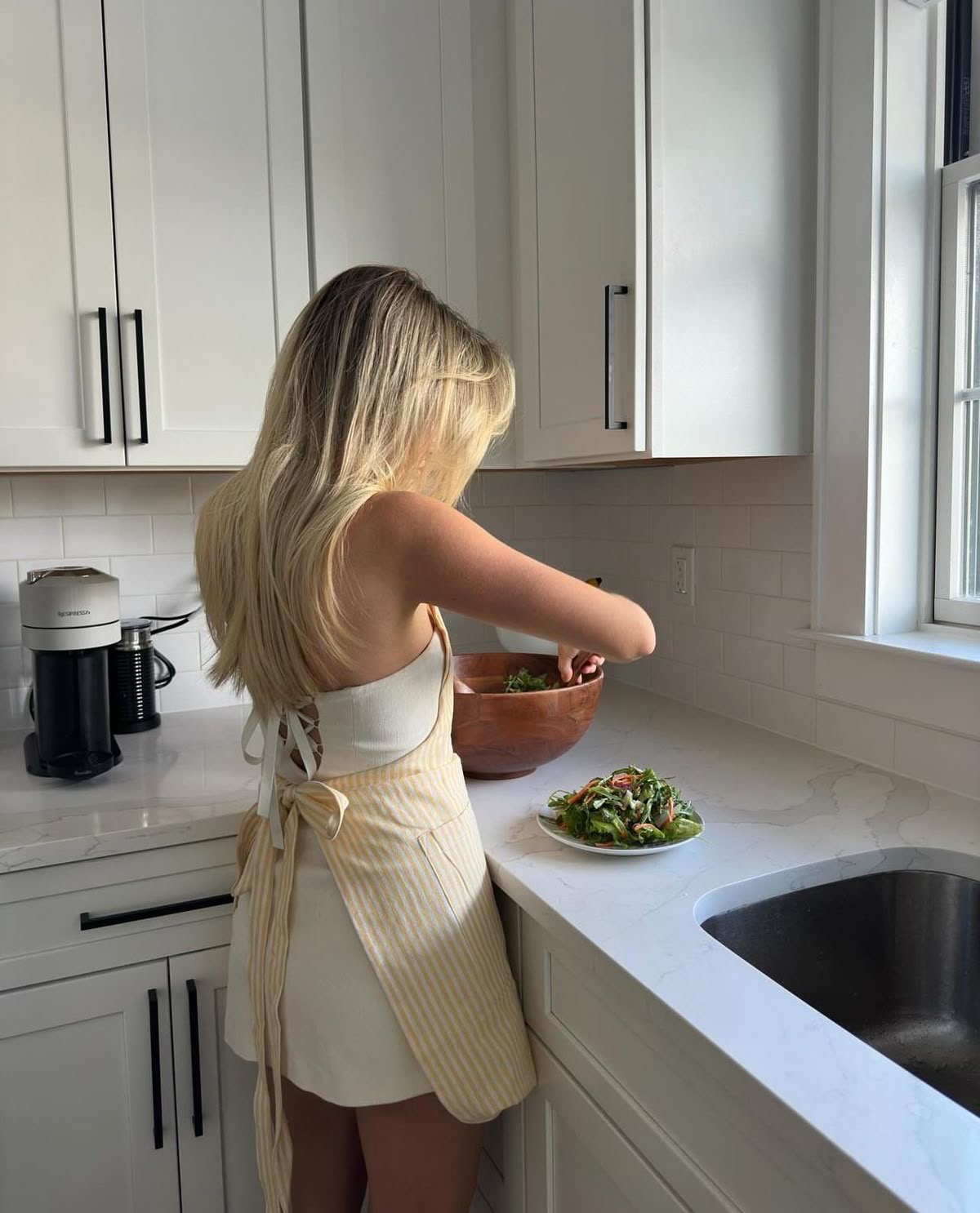 Mulher preparando uma refeição em uma cozinha clara